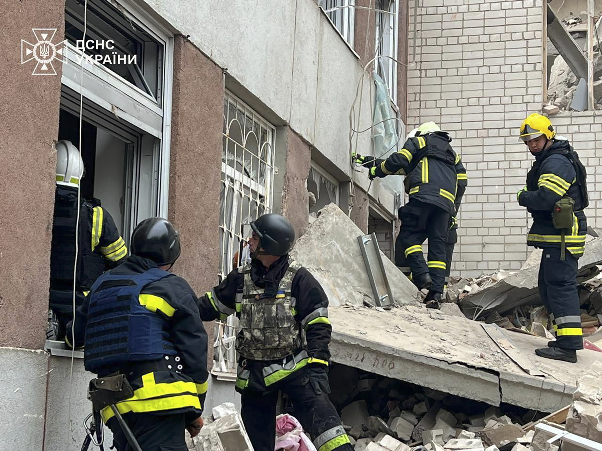 Los bomberos de Chernigov trabajan en los escombros de uno de los edificios atacados por Rusia.