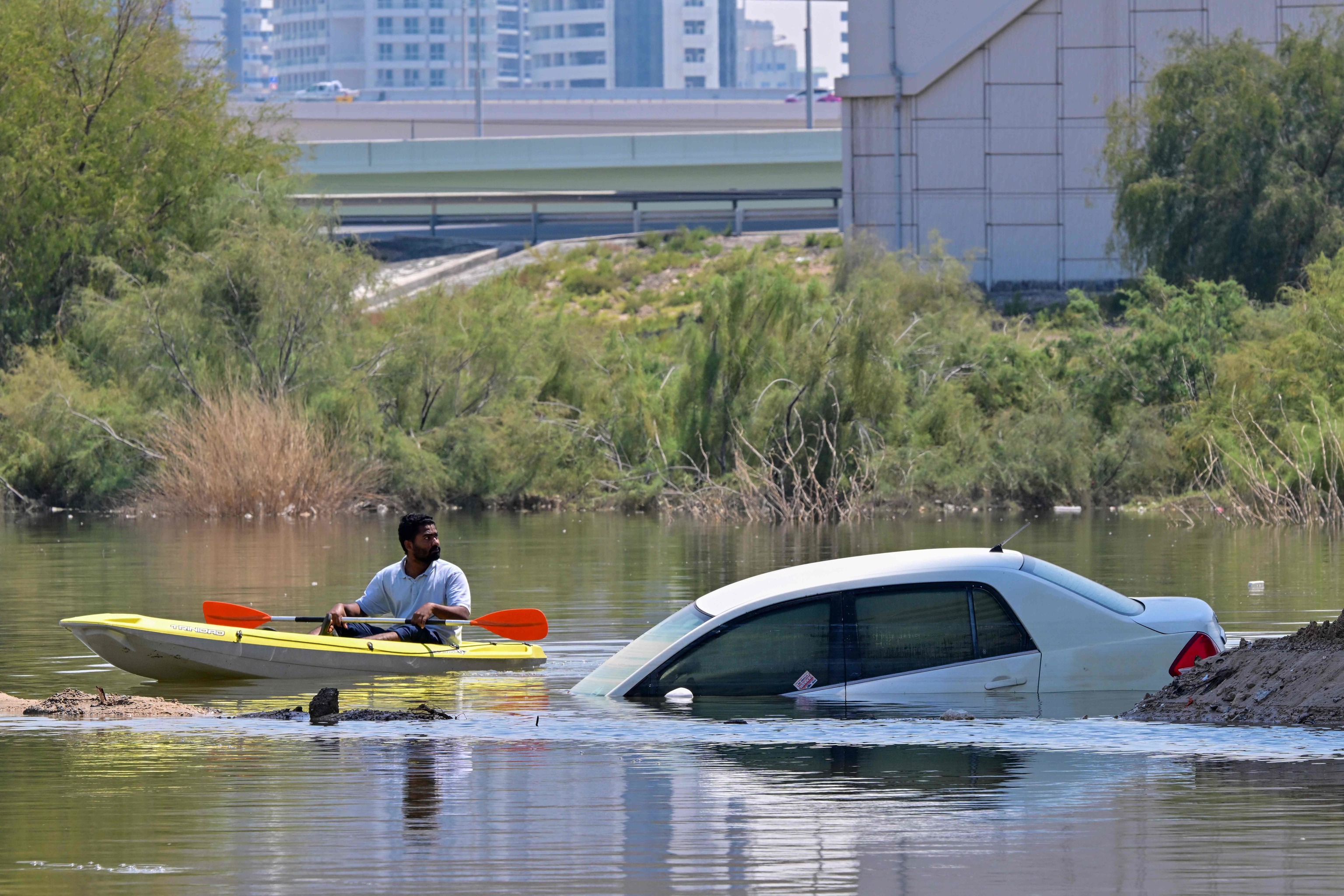 Un hombre se desplaza en canoa por una calle inundada en Dubi