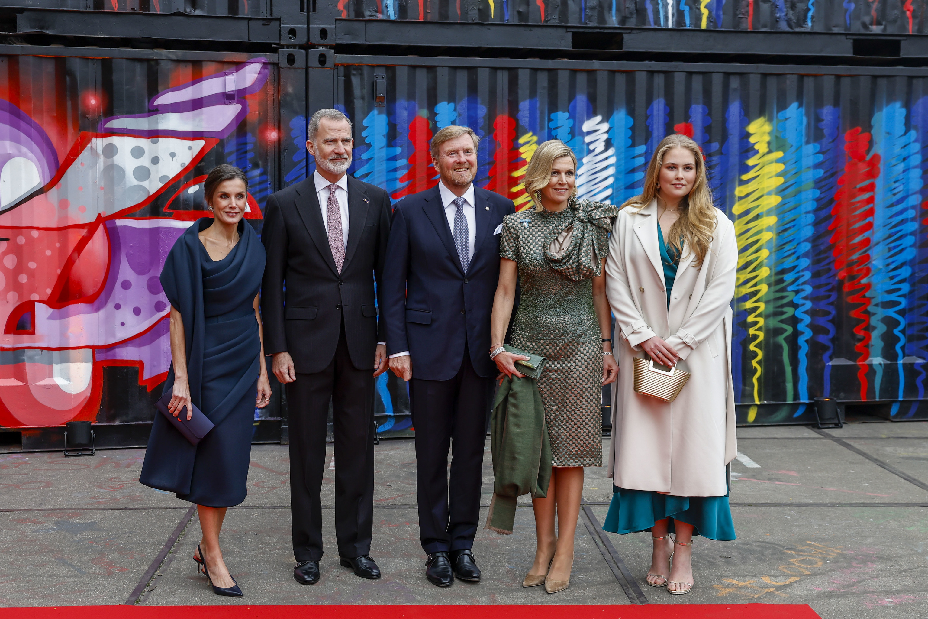 El rey Felipe y la reina Letizia posan junto a los reyes de los Pa�ses Bajos frente a un grafiti de Suso33.