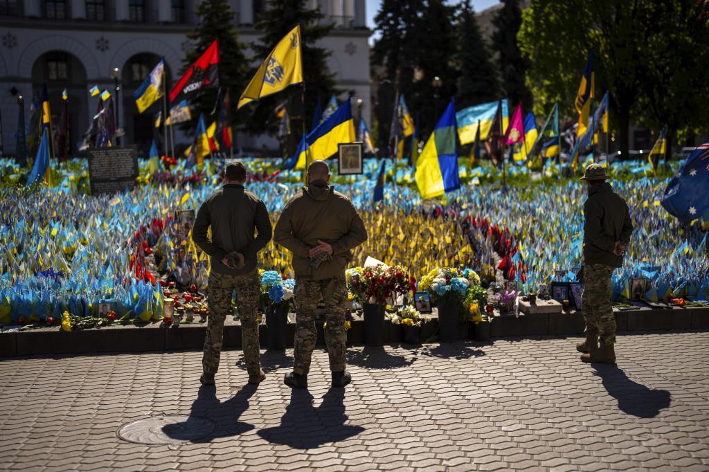 Soldados ucranianos junto a banderas ucranianas y fotografas en memoria de civiles y soldados muertos durante la guerra, en la Plaza de la Independencia de Kiev.