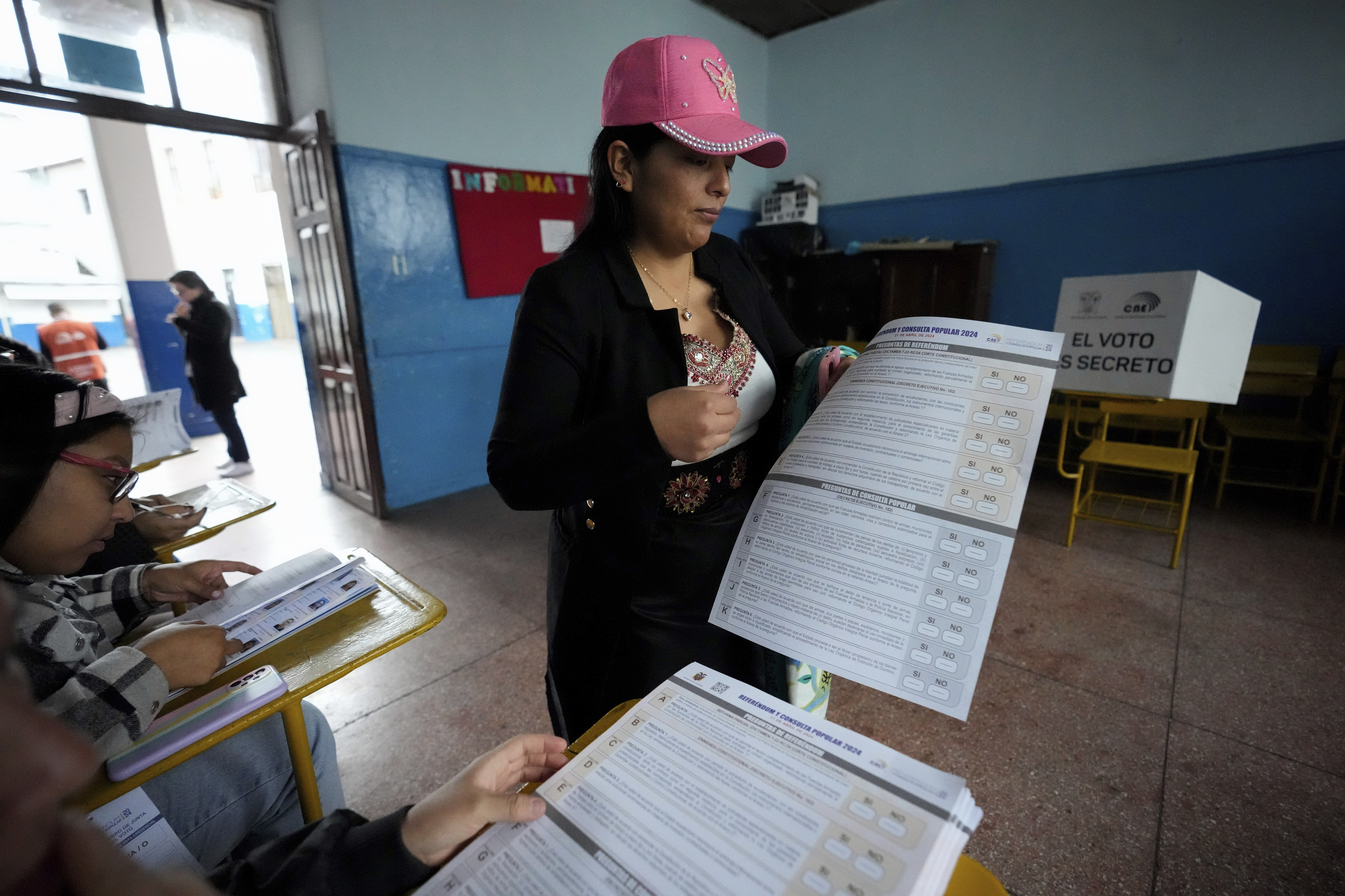 Una mujer sostiene la papeleta para votar en el referndum de este domingo de Ecuador.