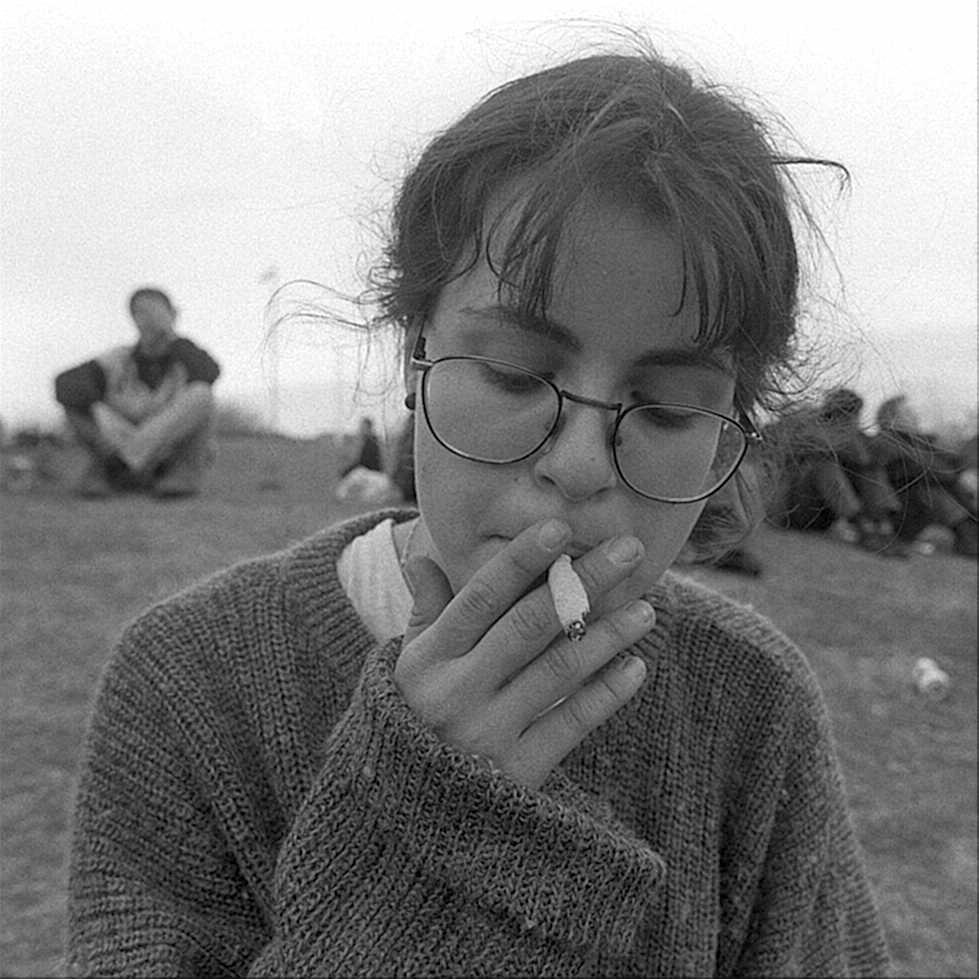 Una jovencita que se rene para fumar