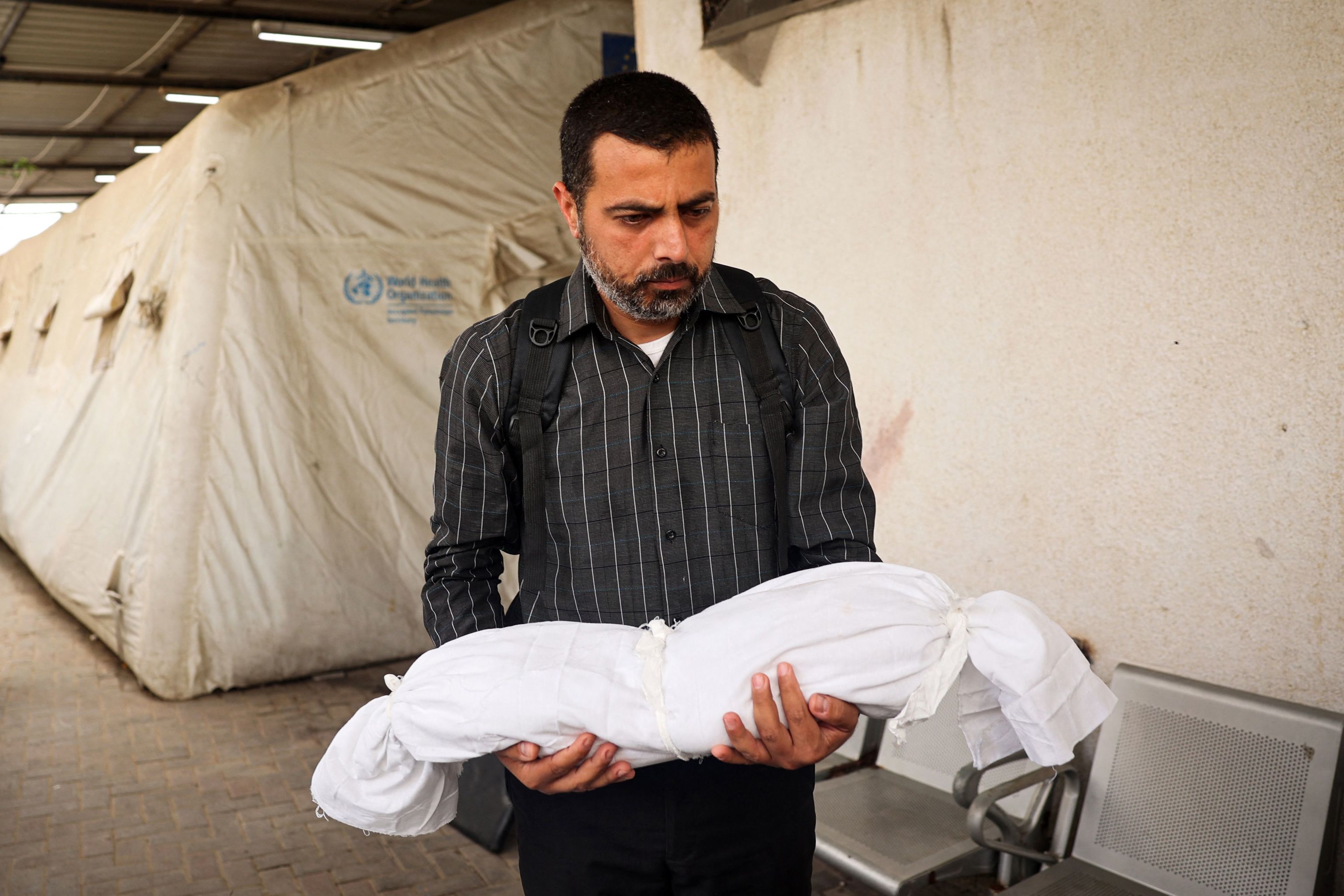 Un hombre sujeta el cuerpo de un beb en Rafah.