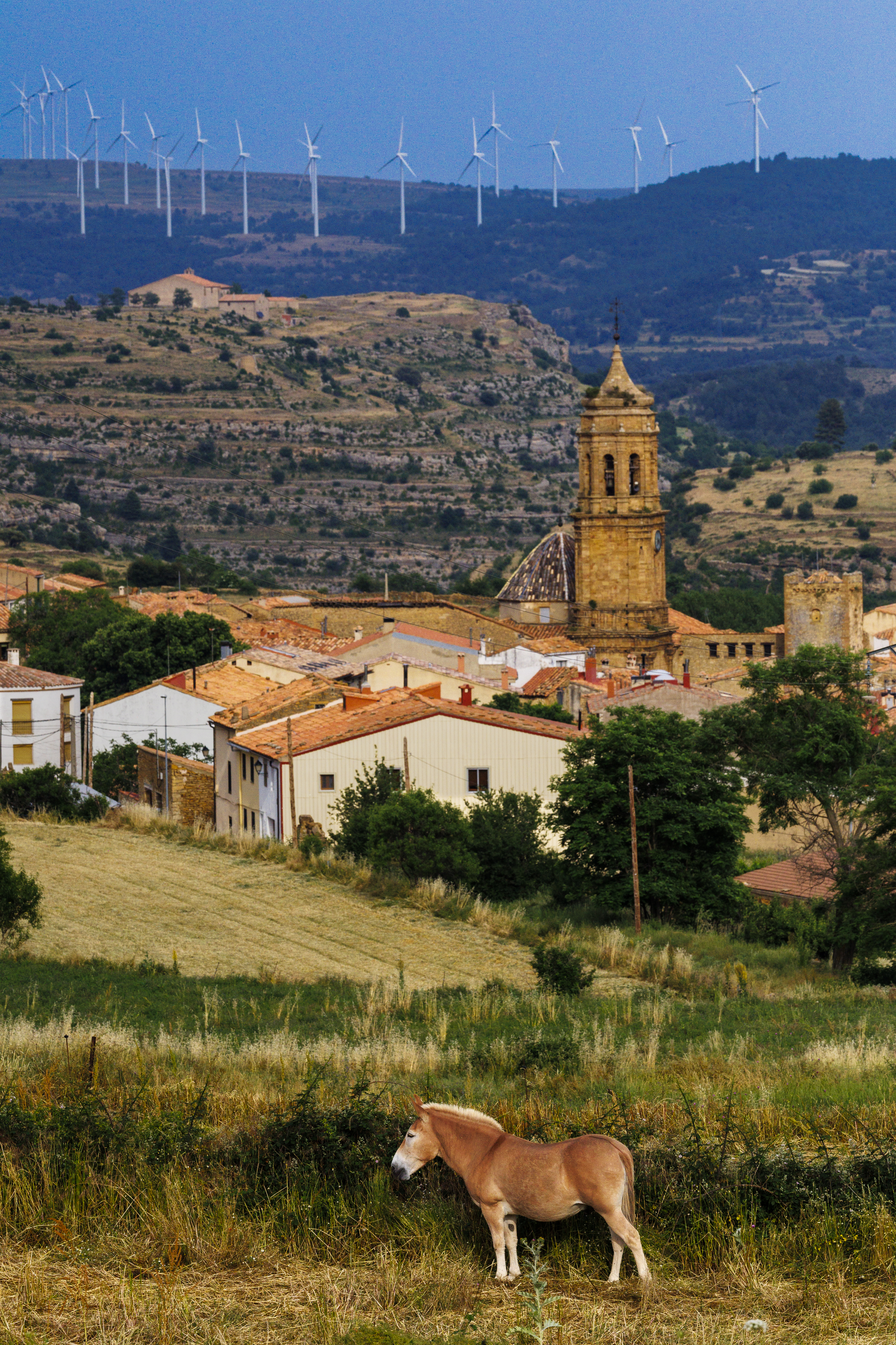 Iglesuela del Cid, con un parque eólico al fondo.