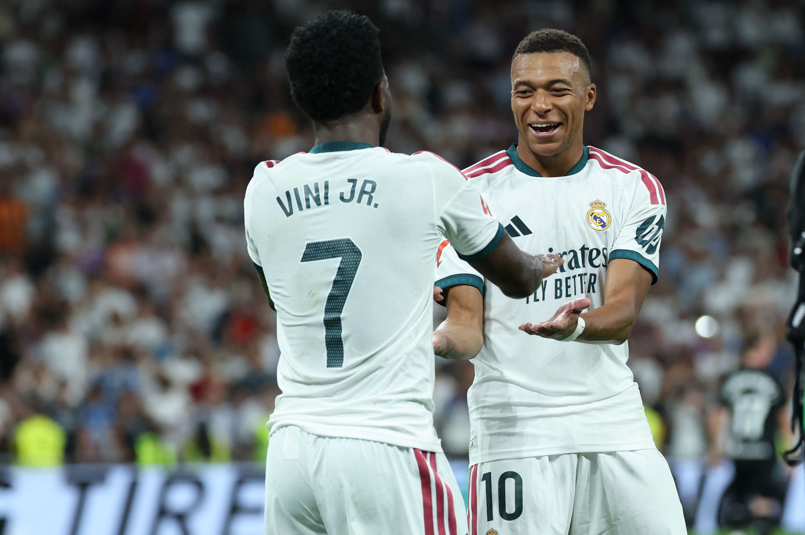 Real Madrid's Brazilian forward #07 Vinicius Junior (L) celebrates scoring his team's third goal with Real Madrid's French forward #10 Kylian lt;HIT gt;Mbappe lt;/HIT gt; during the Spanish league football match between Real Madrid CF and Real Sociedad at Santiago Bernabeu Stadium in Madrid on August 26, 2026. (Photo by Thomas COEX / AFP)