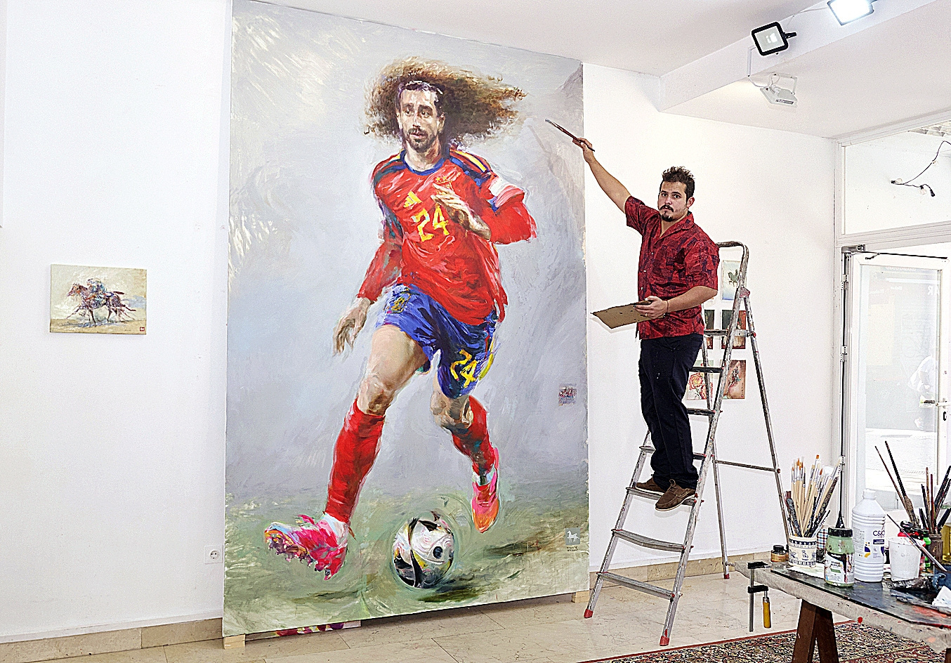 El artista que lleva dos meses pintando un enorme cuadro de Cucurella y que sueña con que el futbolista vaya a verlo: "Le quiero invitar a una paella"