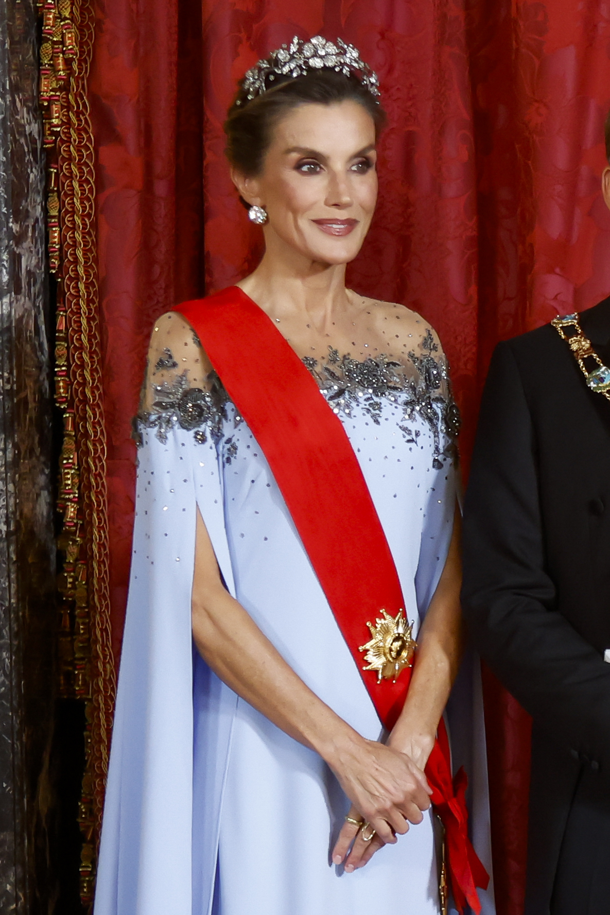 La Reina Letizia brilla con la tiara floral, los pendientes de chatones y un vestido prestado de Carolina Herrera New York, y Brigitte Macron con un look blanco y plata