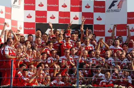 La escudería Ferrari, con Alonso en el centro, celebra su triunfo en Monza.