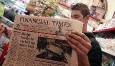 Un joven lee una información de Financial Times acerca del euro