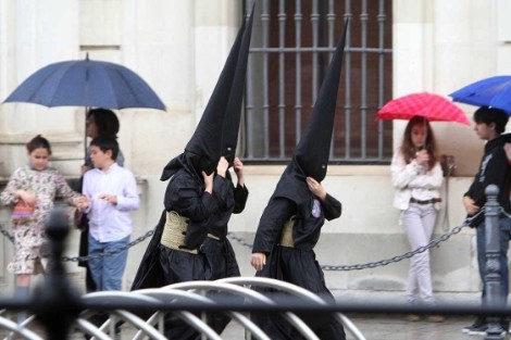 Nazarenos de los Estudiantes caminan entre paraguas. Foto: Carlos Márquez