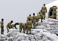 Soldados iranes descargan ayuda humanitaria de un avin saud. (EFE)