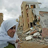 Una mujer ante viviendas derrumbadas en la población de Imzuren. (AFP) VEA MÁS IMÁGENES