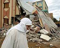 Una mujer ante viviendas derrumbadas en la población de Imzuren. (AFP)