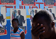 Haitianos delante de un poster del ex presidente Aristide.(AP)