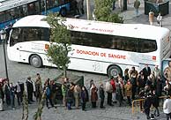 Una larga fila de donantes ante un autobús de Cruz Roja. (EFE)