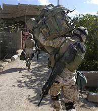 Soldados de EEUU trasladan material al interior de una casa en Faluya. (AP)