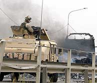 Un blindado de EEUU, junto a un camión calcinado cerca de Bagdad. (AFP)