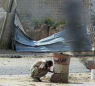 Un joven se protege de los misiles israeles en Gaza. (AFP)