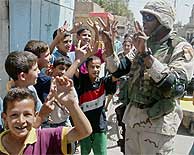 Un soldado estadounidense juega con un grupo de nios en Bagdad. (AFP)