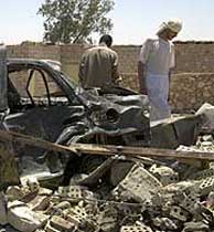 Dos iraques recorren los escombros de dos viviendas en Faluya tras el bombardeo de EEUU. (AP)