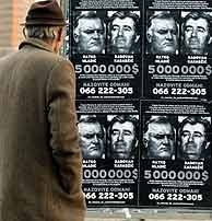 Un hombre mira los carteles que ofrecen una recompensa por Karadzic (dcha) y Ratko Mladic. (AFP)
