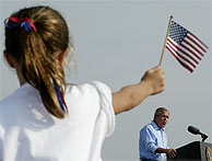 Una nia sujeta una bandera de EEUU durante un discurso de Bush en Ohio. (AP)