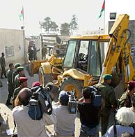 Una excavadora entra en el complejo de la Muqata. (AFP)