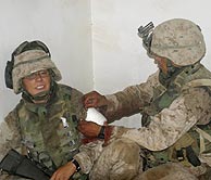 Un mdico militar cura las heridas de un marine en Faluya. (AFP)