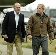 El Rey Juan Carlos (izda.) pasea con George W. Bush. (REUTERS)