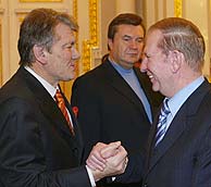 Yushchenko (izda.) y Kuchma se saludan ante la mirada de Yanukovich. (AP)