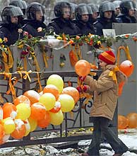 Una nia coloca un globo frente a un cordn policial en Kiev. (AP)