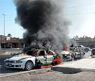 Dos coches de la polica iraqu arden tras un ataque de los insurgentes en Ramadi. (Foto: REUTERS)