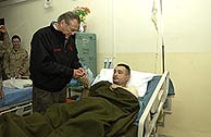 Rumsfeld, visitando a uno de los heridos en el ataque del martes. (Foto: AP)