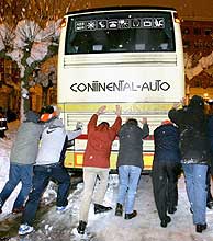 Un grupo de viajeros empuja un autobs atrapado por la nieve en Burgos. (Foto: Too Gallego)