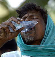 Un pescador indio bebe agua de una bolsa facilitada por la ayuda internacional. (Foto: AFP)