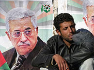 Un palestino fuma junto a un cartel de Abu Mazen. (Foto: REUTERS)