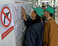 Un cartel que prohbe llevar armas se exhibe en un centro electoral de Beit Hanoun (Gaza). (Foto: AP)