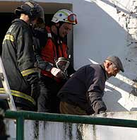 Un bombero ayuda a un anciando a salir del edificio. (Foto: Jess Morn)