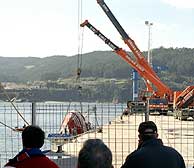Una grúa sostiene al 'Siempre Casina' en el puerto de Celeiro antes de que se proceda a una revisión exhaustiva de su interior. (Foto: EFE),