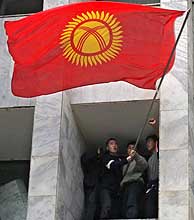 Un grupo opositor ondea la bandera kirgus desde una ventana de la sede del Gobierno. (Foto: EFE)