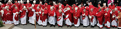 Varios cardenales sujetan sus mitras movidas por el viento durante el funeral por Juan Pablo II. (AP)