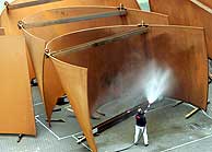 Un operario del Guggenheim riega las esculturas de Serra para favorecer la oxidacin. (Foto: Iaki Andrs)