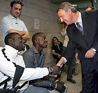 Caldera saluda a un inmigrante en una oficina de Madrid. (Foto: EFE)