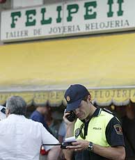 Un polica, frente a la joyera de Mstoles. (Foto: EL MUNDO)