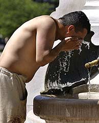 Un hombre se refresca en una fuente. (Foto: EFE)