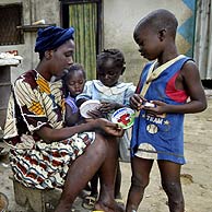 Una mujer distribuye quesitos entre varios nios en Costa de Marfil. (Foto: AP)