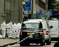 Policas forenses examinan el lugar en el que explot el autobs (a la derecha). (Foto: REUTERS)