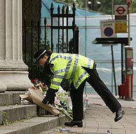 Una polica deja flores cerca de Russell Square. (Foto: REUTERS)
