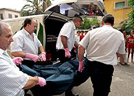 Trabajadores de la funeraria transportan los cuerpos de las vctimas. (Foto: EFE)