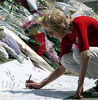 Una mujer escribe un mensaje junto a flores dedicadas a las vctimas en Tavistock Square. (Foto: REUTERS)